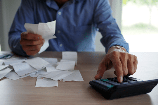 antecipacao de recebiveis homem fazendo contas em uma calculadora. Antecipção de recebiveis
